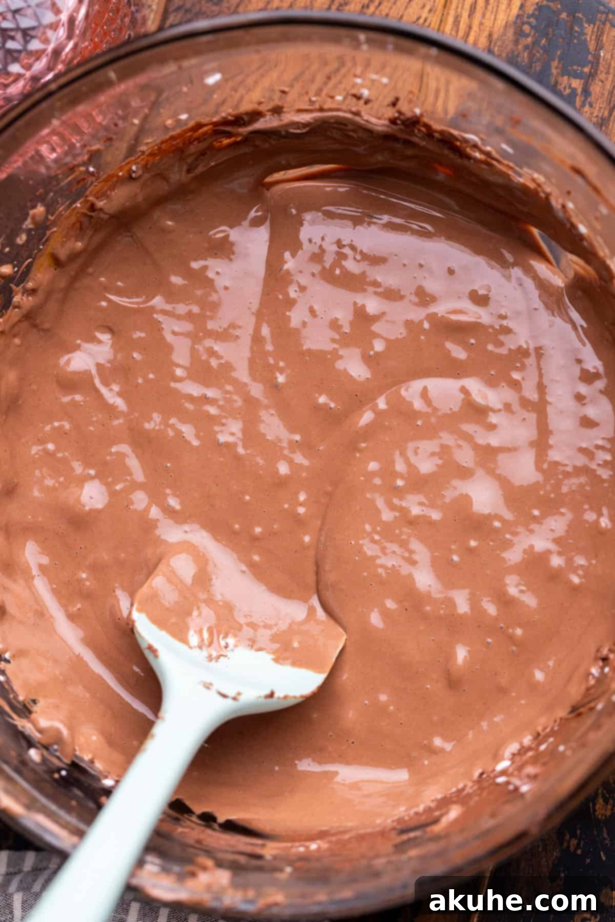 Bite-Sized Chocolate Cheesecakes 5 Smooth and rich chocolate cheesecake batter in a clear glass bowl, showcasing its creamy consistency.