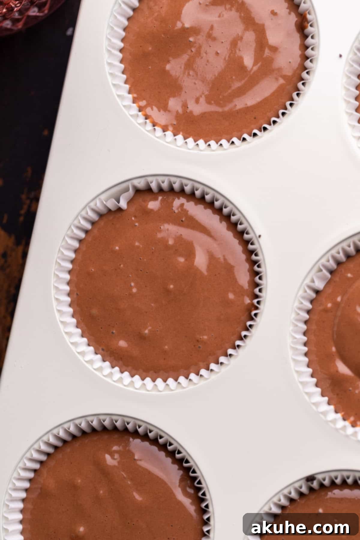 Bite-Sized Chocolate Cheesecakes 6 Muffin tin filled with creamy chocolate cheesecake batter, perfectly portioned over the Oreo crust.