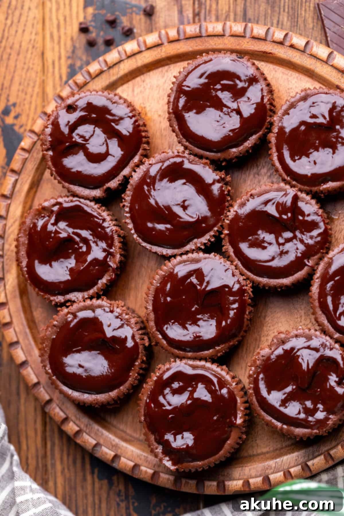 Bite-Sized Chocolate Cheesecakes 8 Smooth chocolate ganache being spooned onto the cooled mini cheesecakes, creating a rich, glossy layer.
