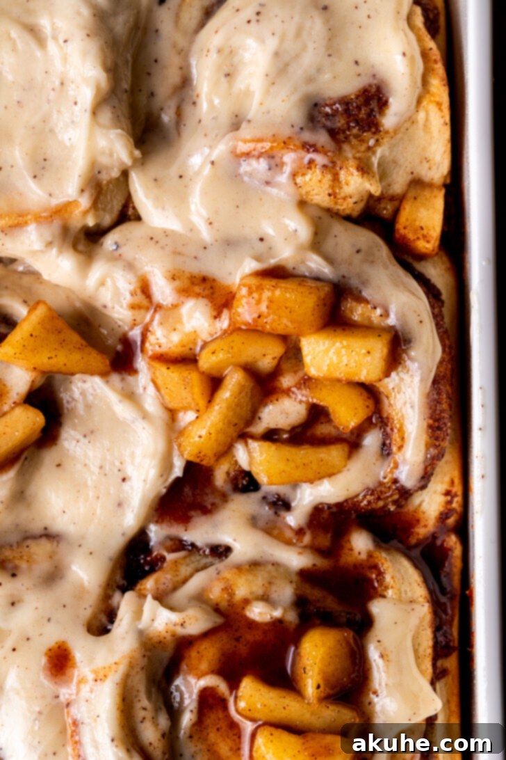 Homemade Apple Cinnamon Rolls 10 Top-down view of a pan full of perfectly baked apple cinnamon rolls, glistening with icing.