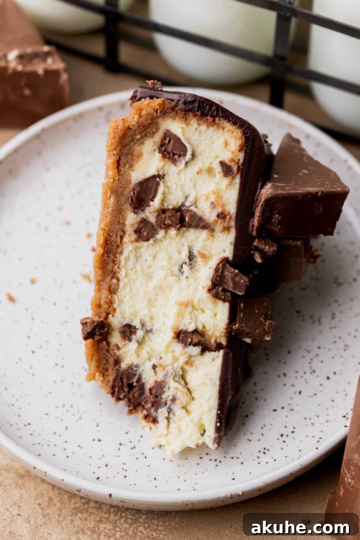 Decadent Toblerone Cheesecake 12 One exquisite slice of cheesecake elegantly presented on a white plate, ready to be enjoyed.