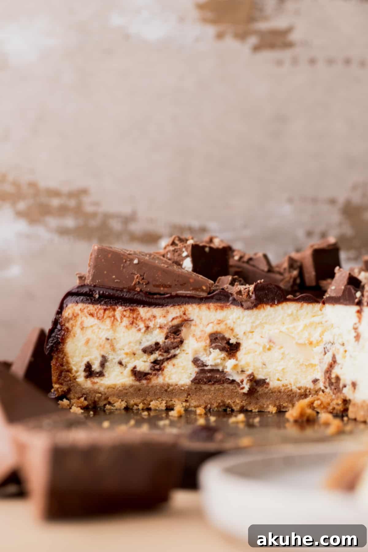 Decadent Toblerone Cheesecake 3 Half of the Toblerone cheesecake on a wood board, showing the vibrant chocolate ganache and triangular chocolate pieces.