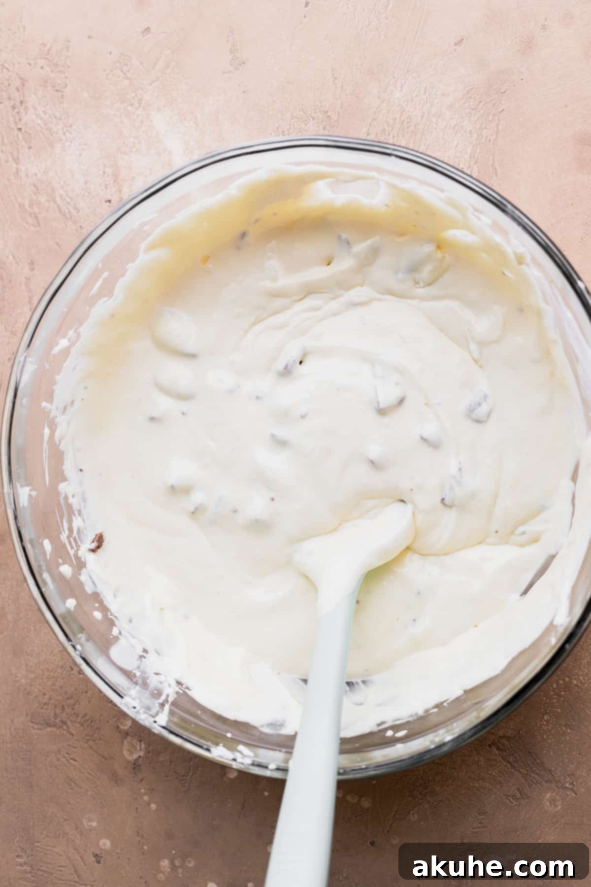 Decadent Toblerone Cheesecake 7 Smooth cheesecake batter in a glass bowl, showcasing its creamy consistency.