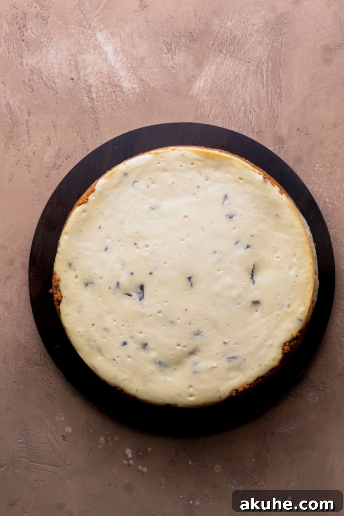 Decadent Toblerone Cheesecake 9 Baked cheesecake resting on a board after cooling, awaiting its final decorations.