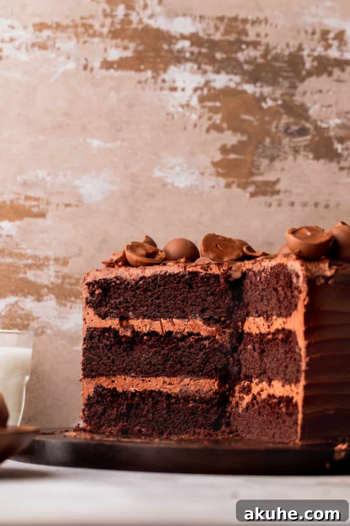 Chocolate truffle cake split in half on a wood board, showcasing its moist layers and rich filling with truffle swirls.