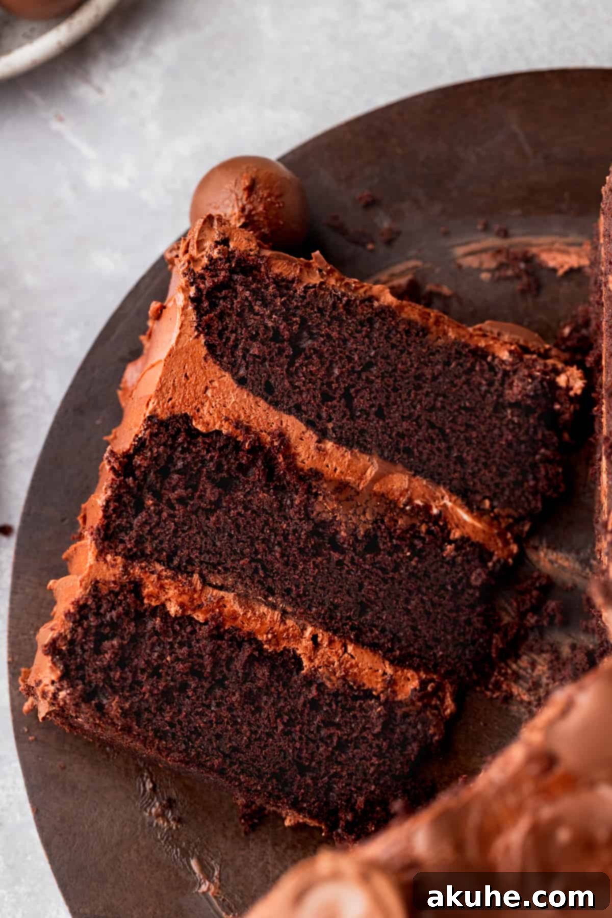 A tantalizing single slice of chocolate truffle cake resting on a wood board, perfectly cut to showcase its rich, layered texture and inviting appeal.