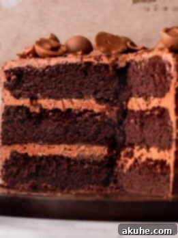 Chocolate truffle cake split in half on a wood board.