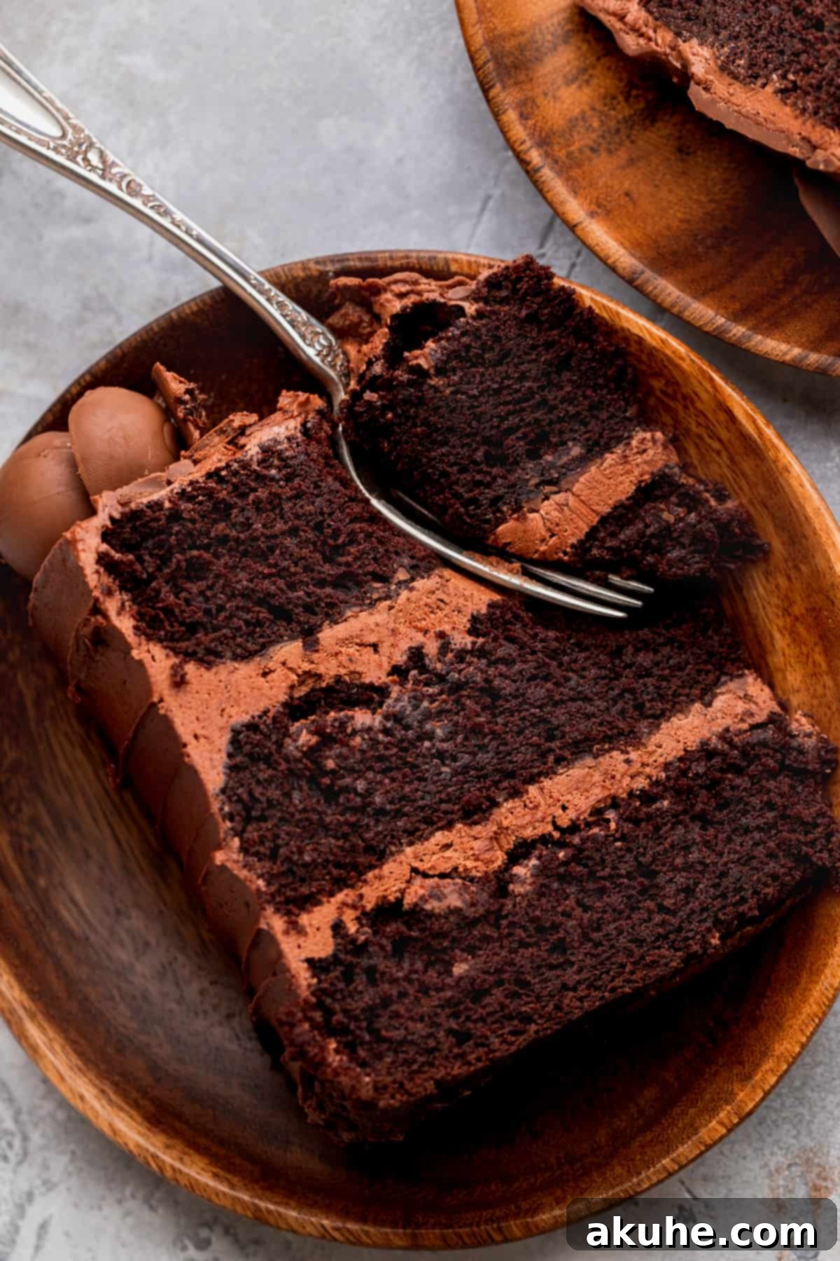 A single, perfectly cut slice of chocolate truffle cake on a plate, showing the rich, moist layers, creamy frosting, and visible truffle swirls.