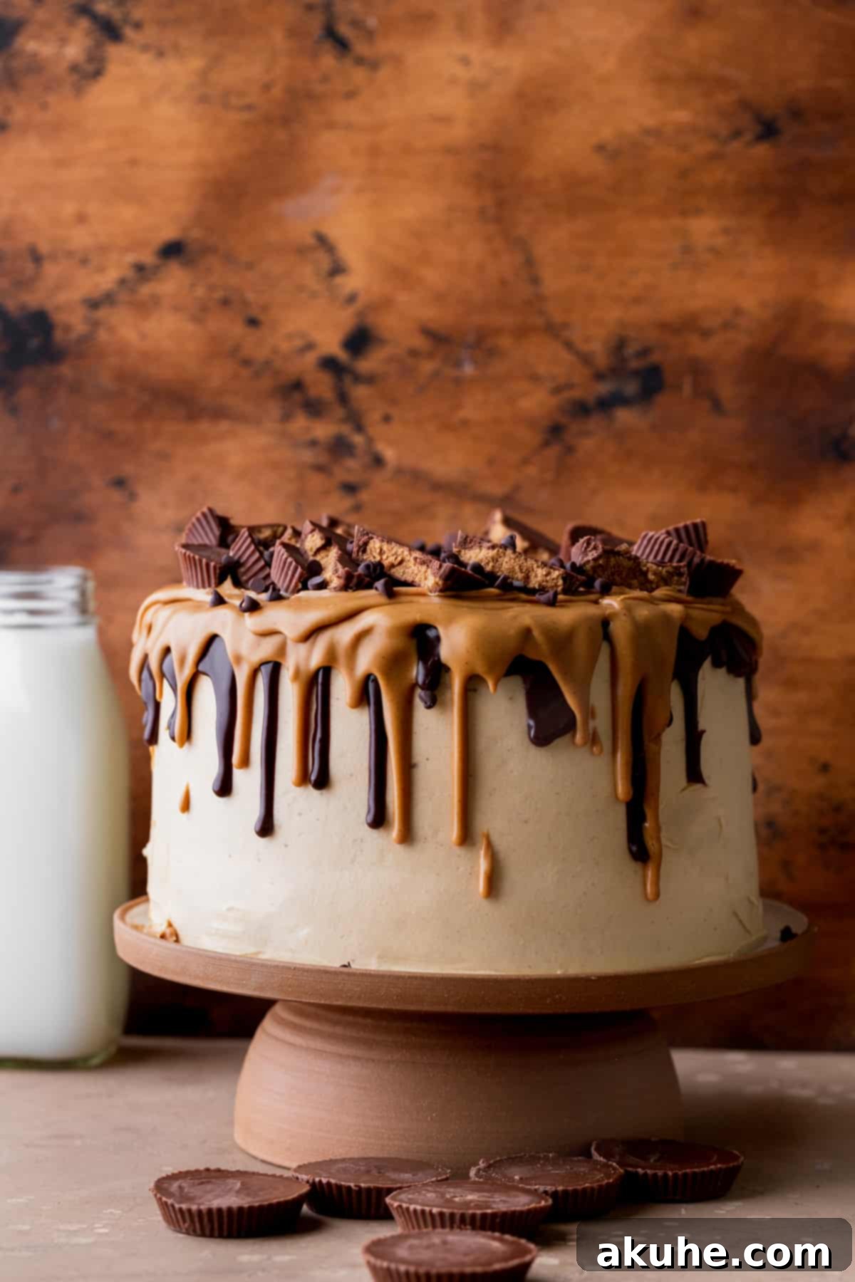 Decadent Peanut Butter Chocolate Cake 3 Beautifully decorated chocolate peanut butter cake on a elegant cake stand, ready to be served.