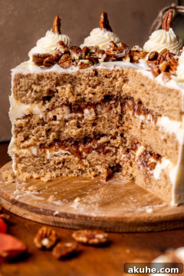 An exquisitely baked Pecan Pie Cake is artfully split open on a rustic wooden board, revealing the intricate layers of moist spice cake and the abundant, caramelized pecan pie filling nestled within each tier.