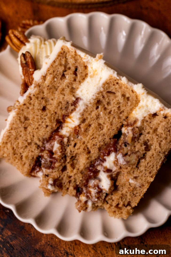 A perfectly portioned slice of Pecan Pie Cake resting on a white plate, ready to be enjoyed.