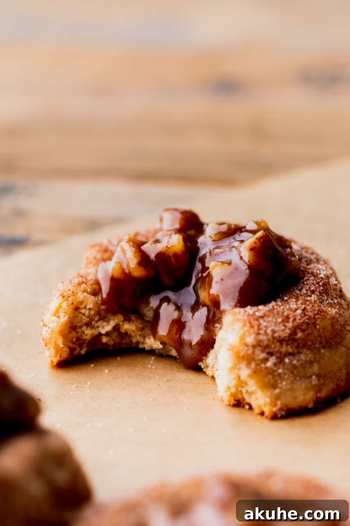 Southern Pecan Pie Cookies 3 Side view of a pecan pie cookie with a perfect bite taken out, revealing the gooey filling and soft cinnamon base.
