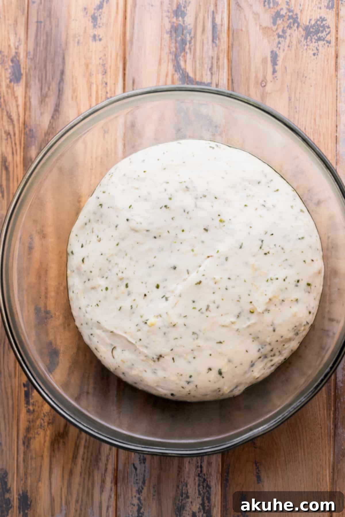 Fresh Baked Garlic Rolls 6 Risen dough in a glass bowl, visibly doubled in size.