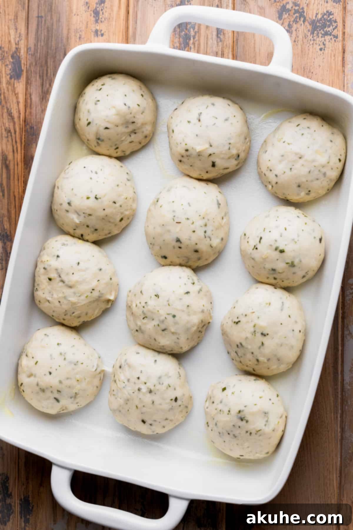 Fresh Baked Garlic Rolls 7 Twelve neatly arranged dough balls in a baking pan.
