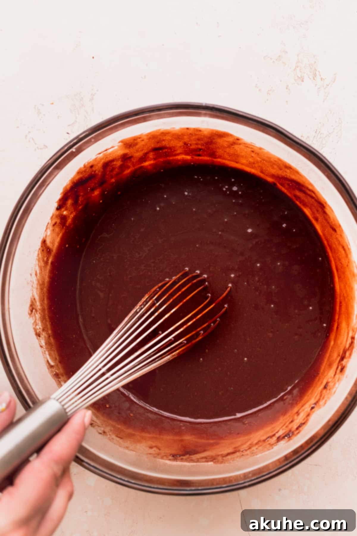 The smooth, rich chocolate cake batter resting in a glass bowl, perfectly mixed and ready for baking.