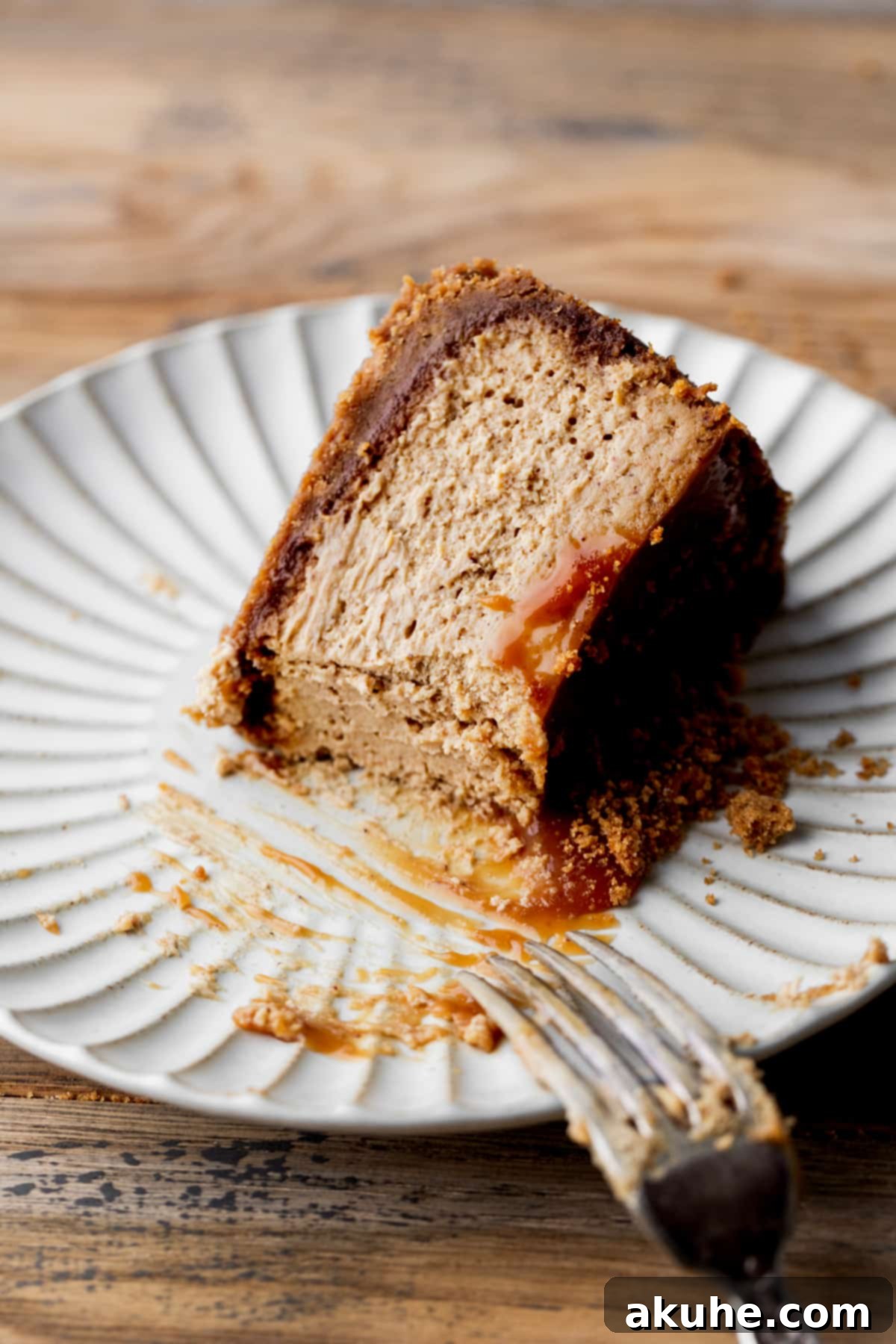 Gingerbread Dream Cheesecake 4 Cut into slice of cheesecake on a plate.