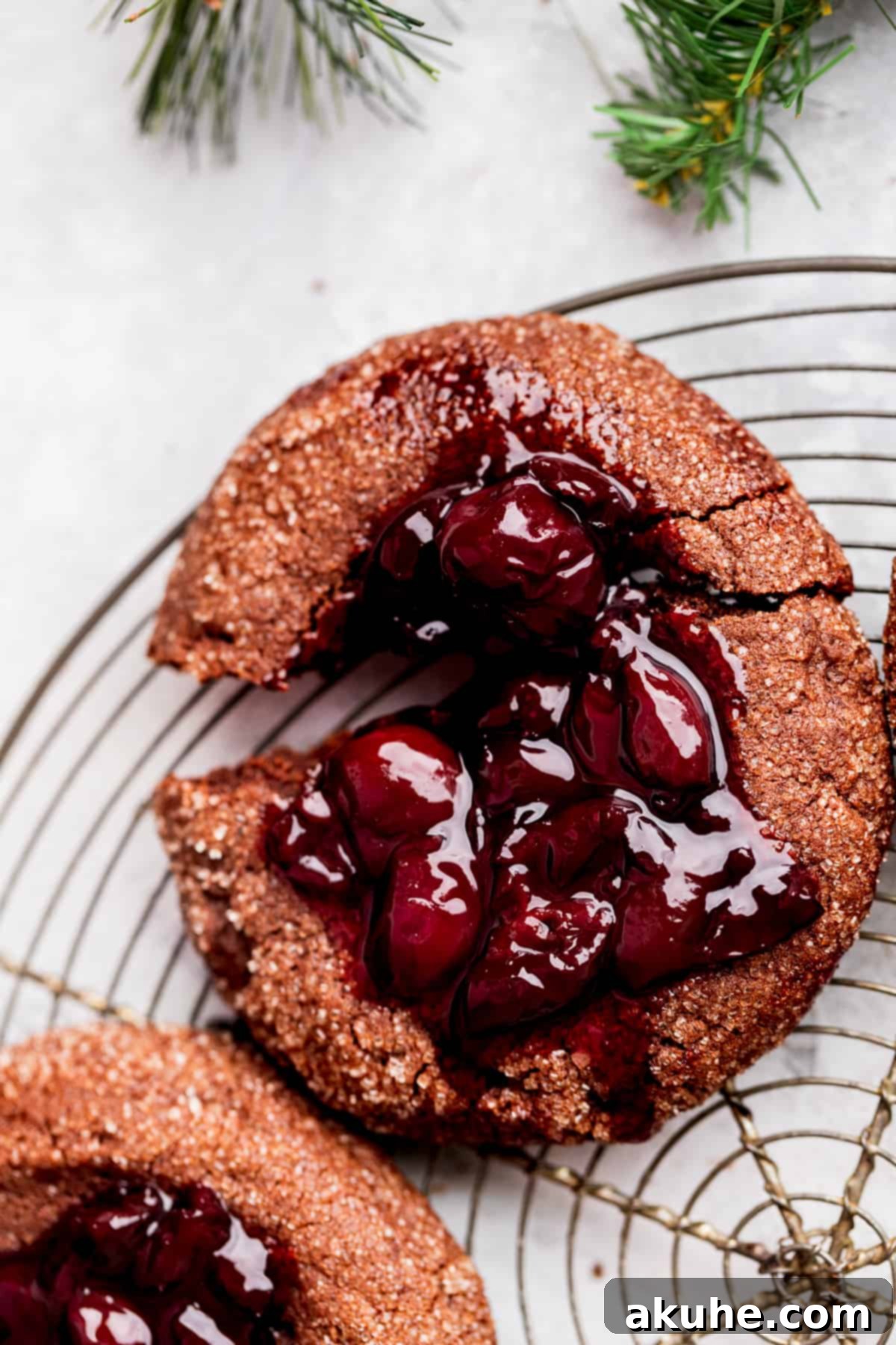 Decadent Chocolate Cherry Cookies 3 A chocolate cherry cookie split in half, showcasing the fudgy interior and cherry filling.