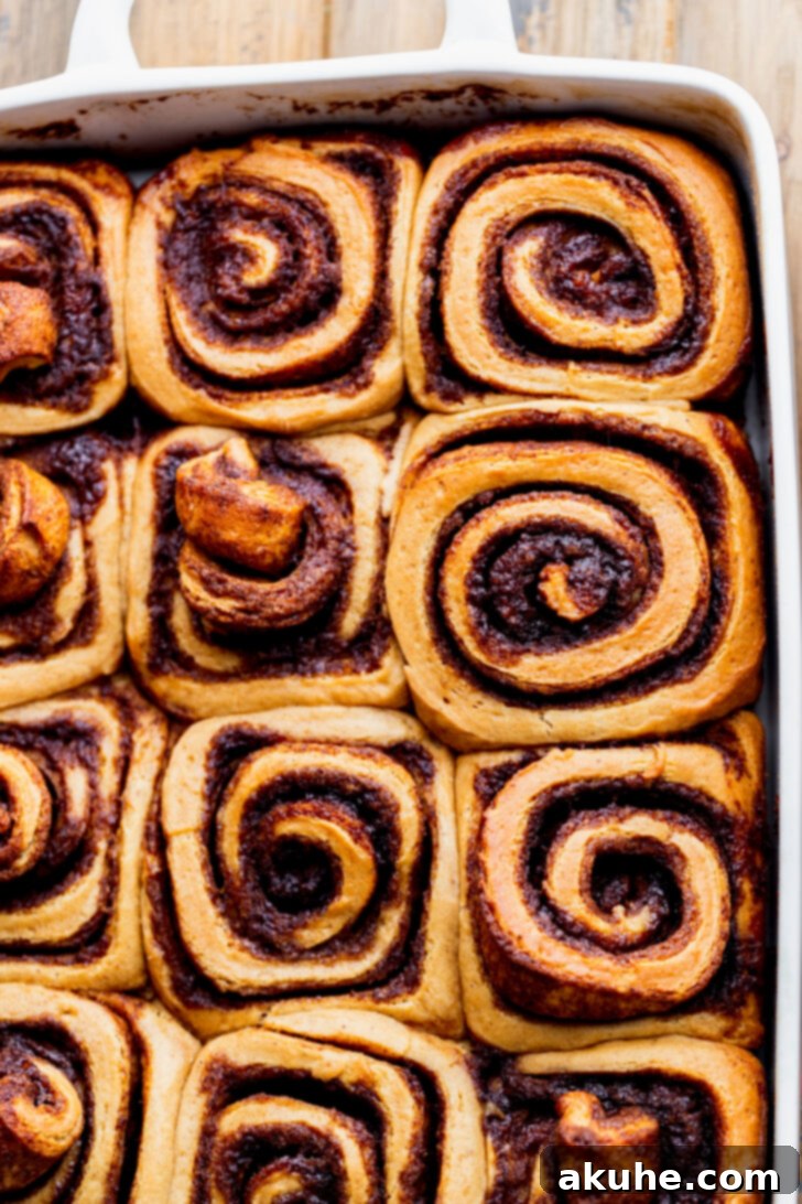 Spiced Gingerbread Swirl Buns 8 Perfectly baked gingerbread cinnamon rolls in a casserole pan, golden brown and ready for icing.