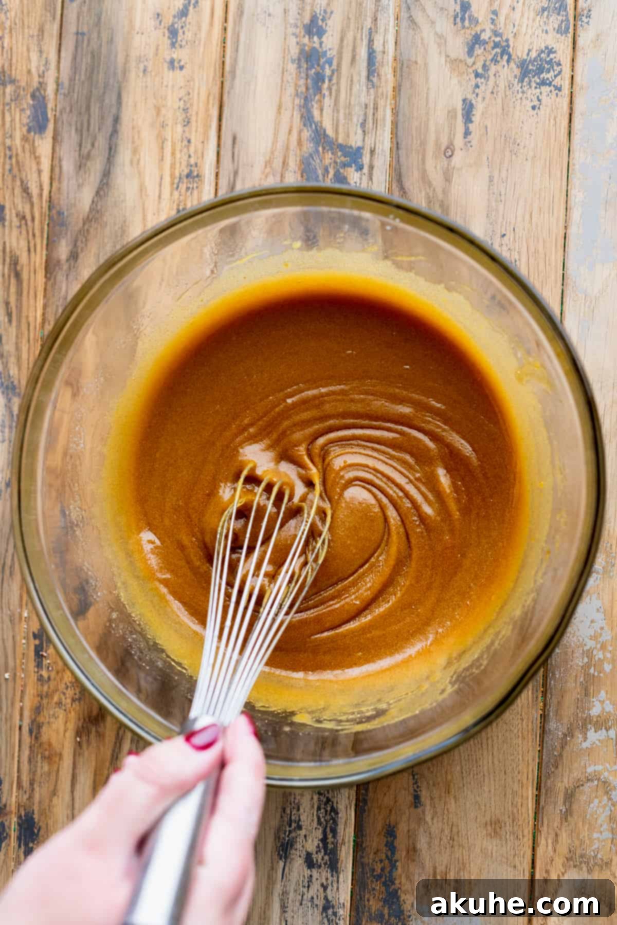 Wet ingredients (melted butter, sugars, egg, molasses) in a glass bowl, ready to be mixed.
