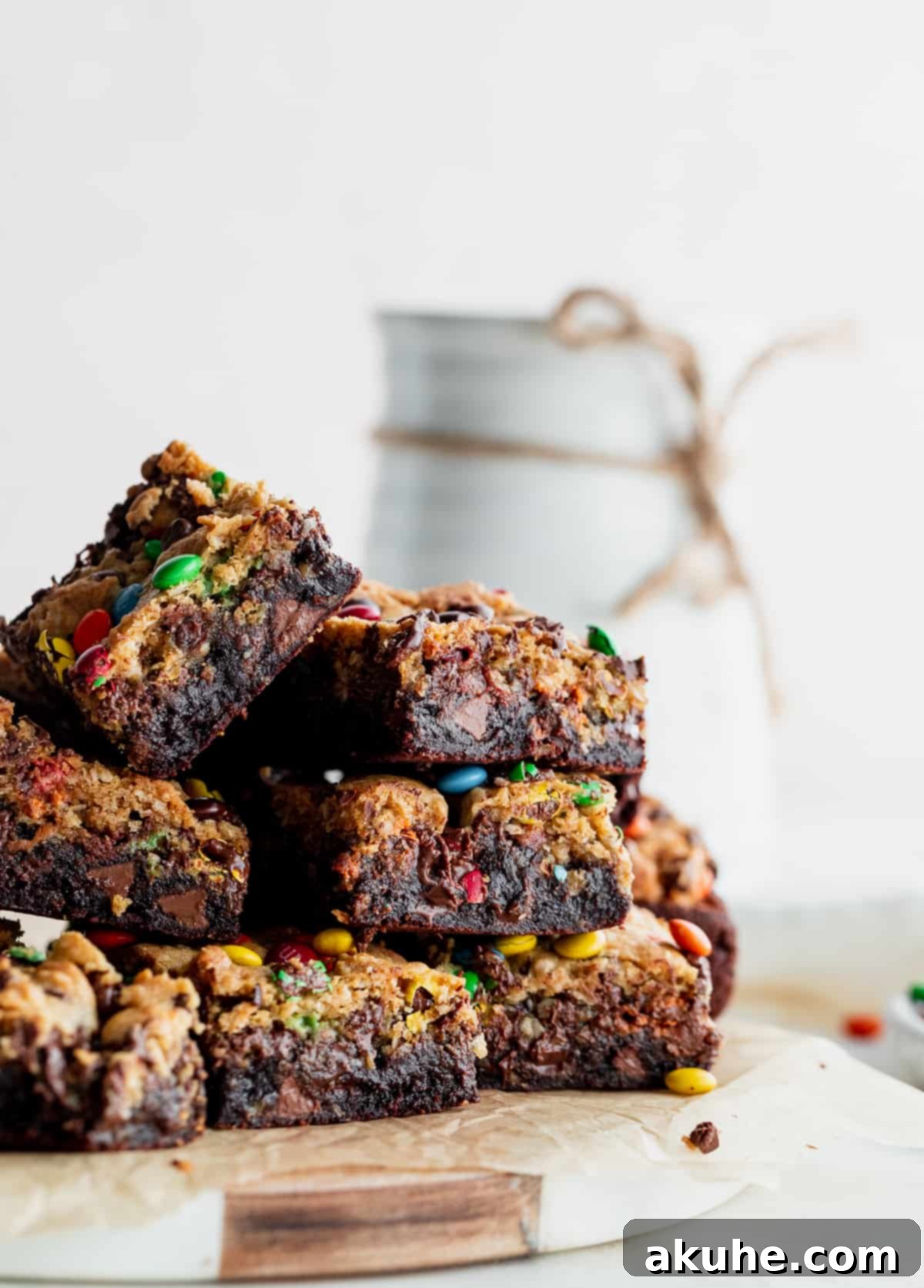 Fudgy Monster Cookie Brownies 2 A tantalizing stack of Monster Cookie Fudgy Brownies, showcasing their distinct layers and rich texture, presented beautifully on a platter.