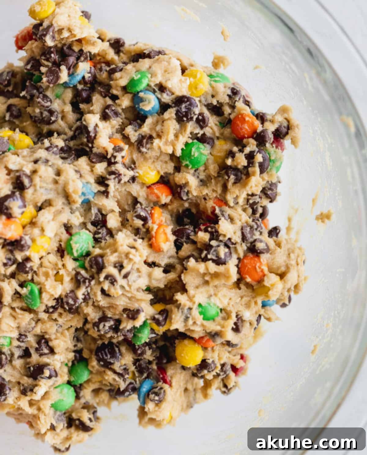Fudgy Monster Cookie Brownies 3 A bowl filled with freshly prepared monster cookie dough, rich with oats, peanut butter, mini M&M's, and chocolate chips, ready for chilling.
