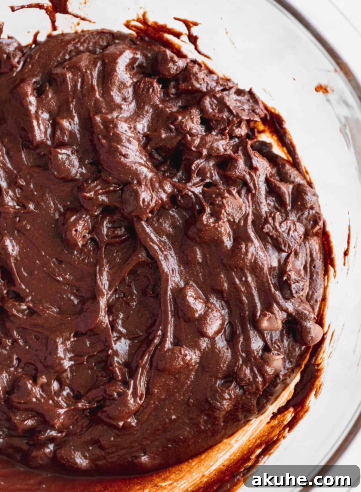 Fudgy Monster Cookie Brownies 4 Rich, glossy brownie batter, infused with two types of chocolate chips, resting in a mixing bowl, ready for baking.
