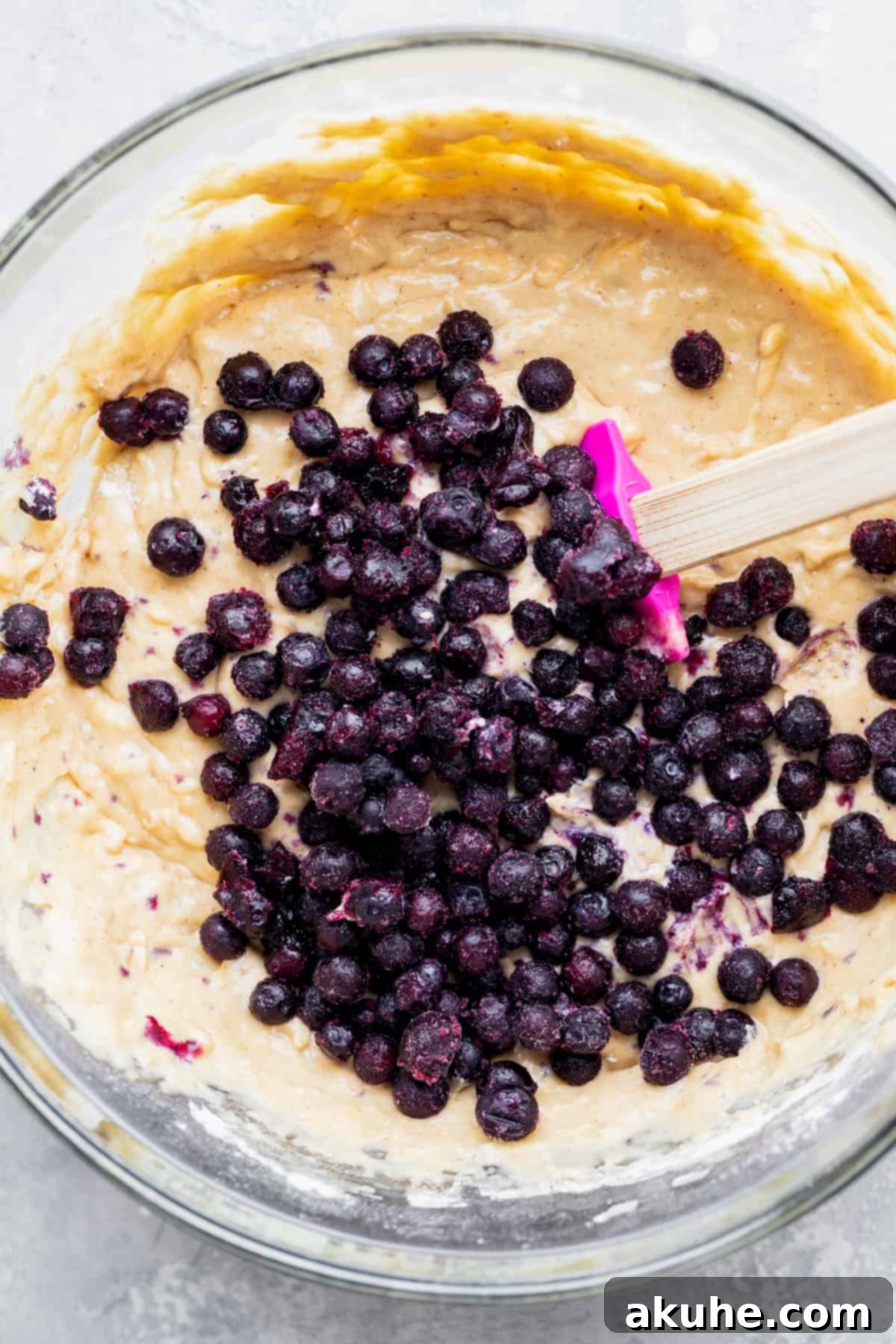 Irresistible Banana Blueberry Muffins 5 Wild blueberries lightly coated with flour resting on top of the muffin batter in a glass bowl, ready to be folded in.