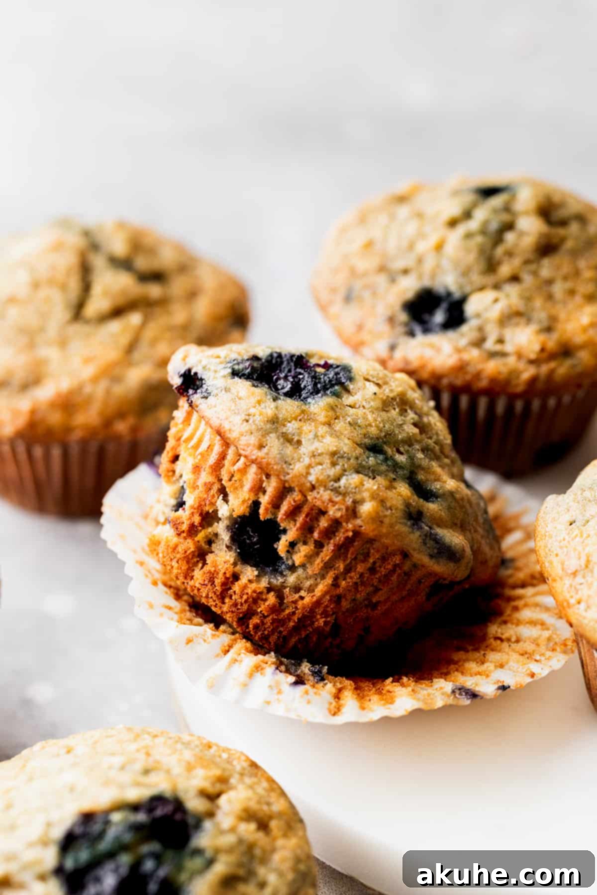 Irresistible Banana Blueberry Muffins 8 A banana blueberry muffin cut in half, revealing its moist interior, fluffy texture, and evenly distributed blueberries.