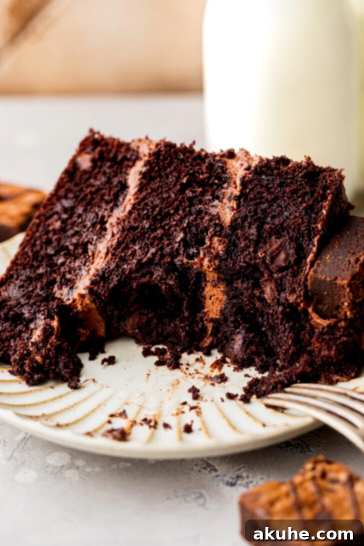 Fudgy Brownie Cake 13 A delightful slice of brownie cake on a plate, with a bite missing, showcasing its irresistible texture and calling for another taste
