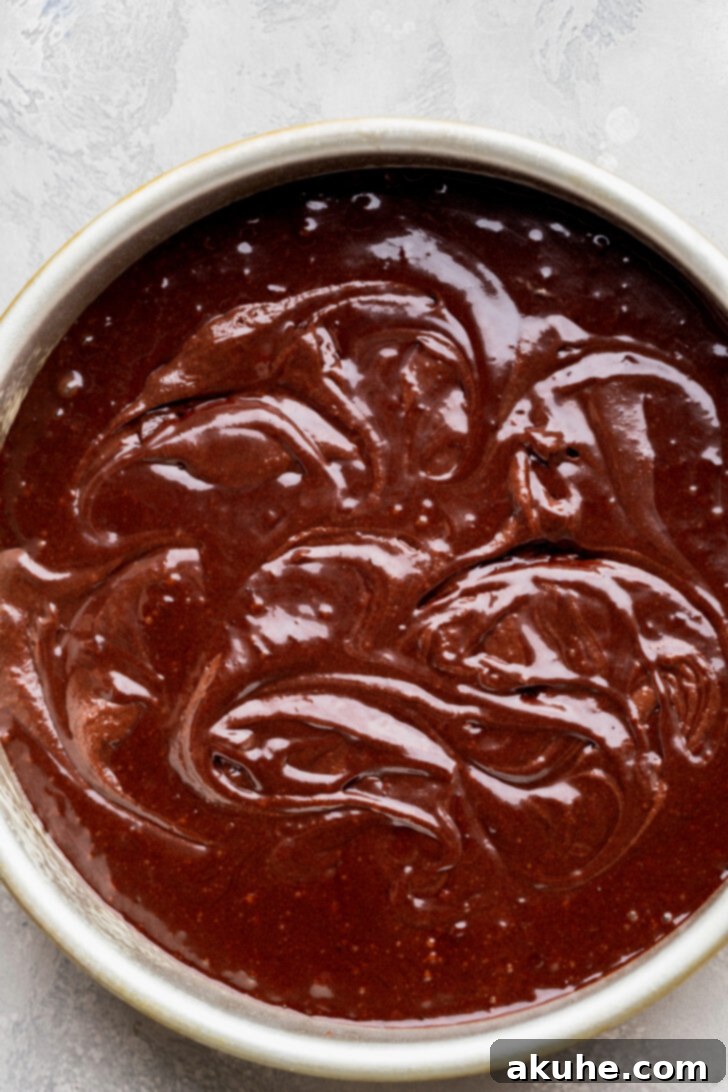 Fudgy Brownie Cake 7 Chocolate cake batter gently swirled with brownie batter in a baking pan, creating a beautiful marbled pattern