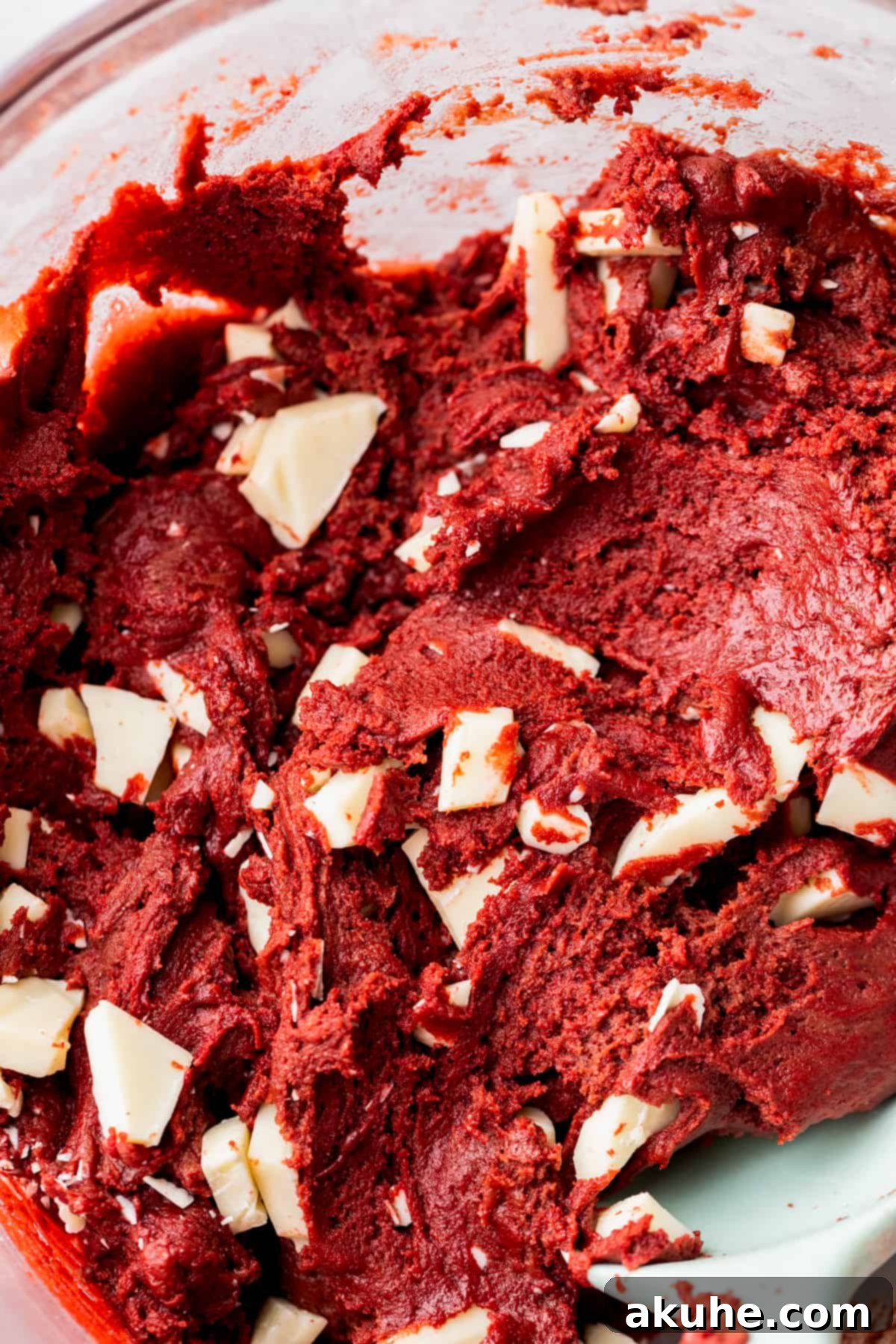 Decadent Red Velvet Cookies 6 Close-up of red velvet cookie dough with visible chunks of white chocolate mixed throughout.