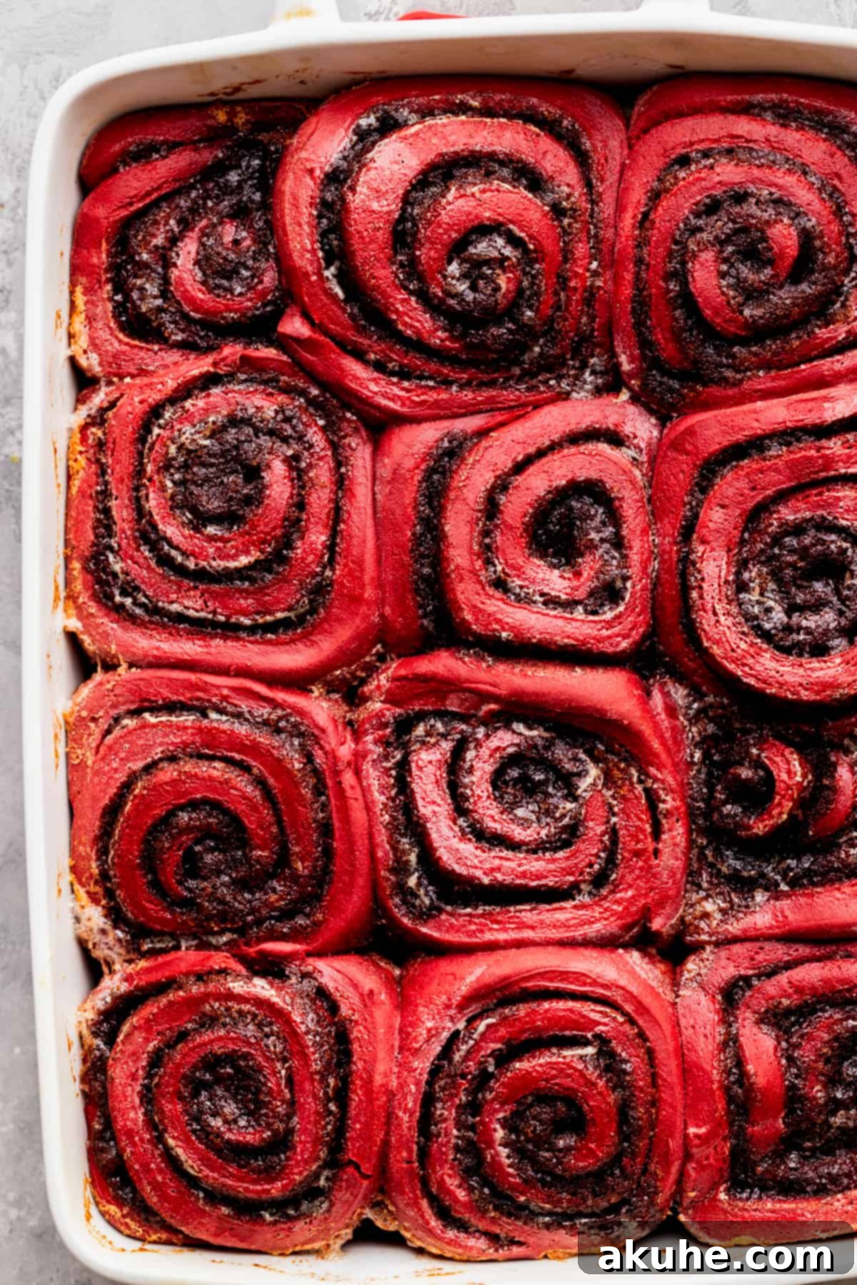 Decadent Red Velvet Cinnamon Rolls 12 Baked cinnamon rolls in a pan.