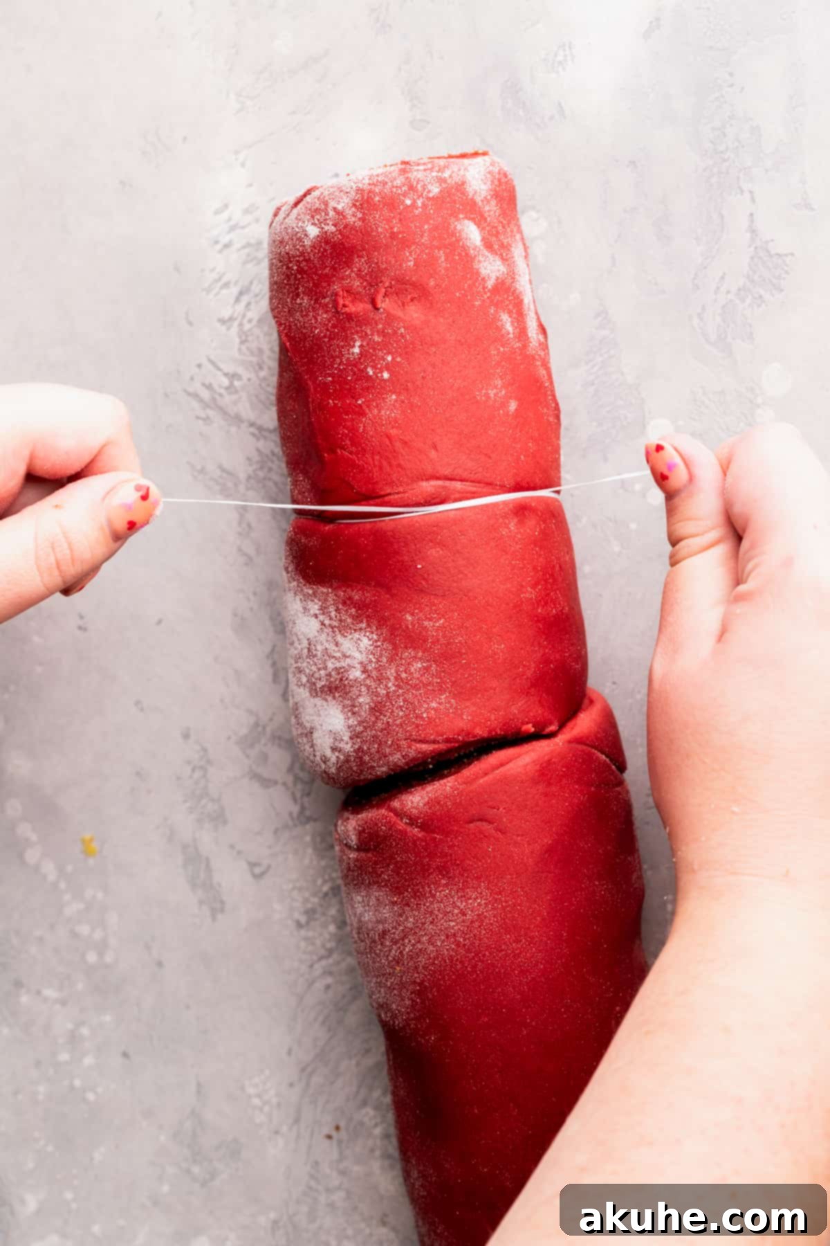 Decadent Red Velvet Cinnamon Rolls 9 Cutting dough with floss.