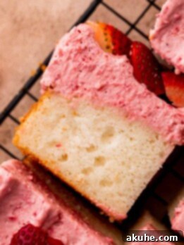 One slice of strawberry mousse cake on a wire rack.