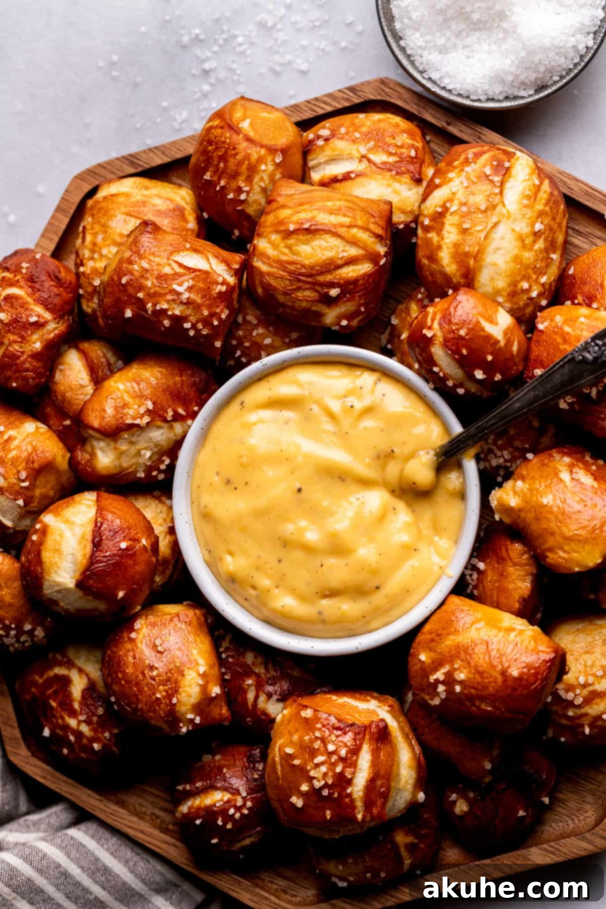 Perfectly Poppable Pretzels 2 Soft pretzel bites on a board with cheese sauce, a perfect homemade appetizer.