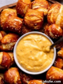 Perfectly Poppable Pretzels 12 Soft pretzel bites on a board with cheese sauce.