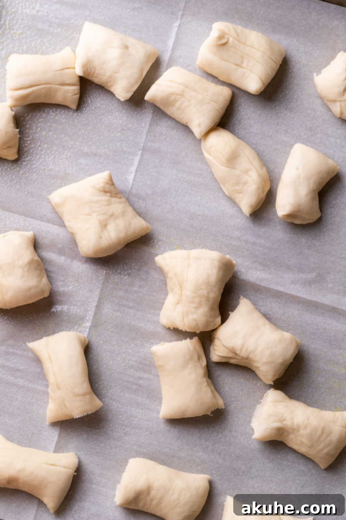 Perfectly Poppable Pretzels 7 Neatly cut raw pretzel dough pieces arranged on parchment paper.