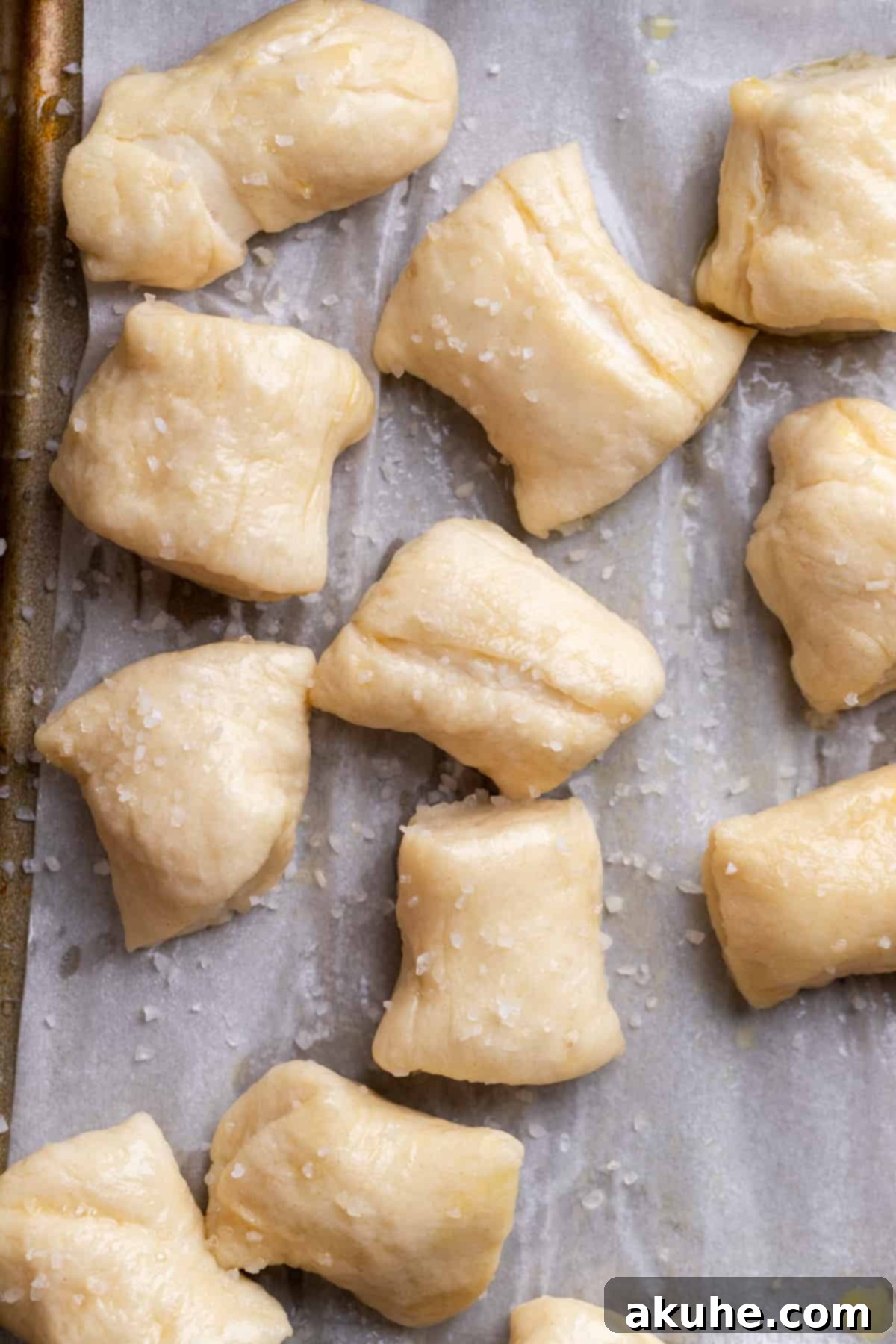 Perfectly Poppable Pretzels 8 Boiled pretzel dough bites, brushed with egg wash and sprinkled with pretzel salt, ready for baking.