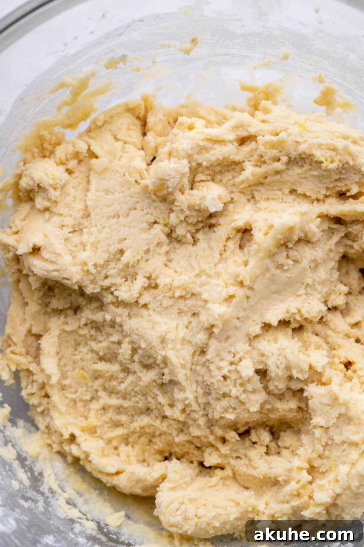 Zesty Lemon Bites 5 Lemon cookie dough in a glass mixing bowl, perfectly mixed.