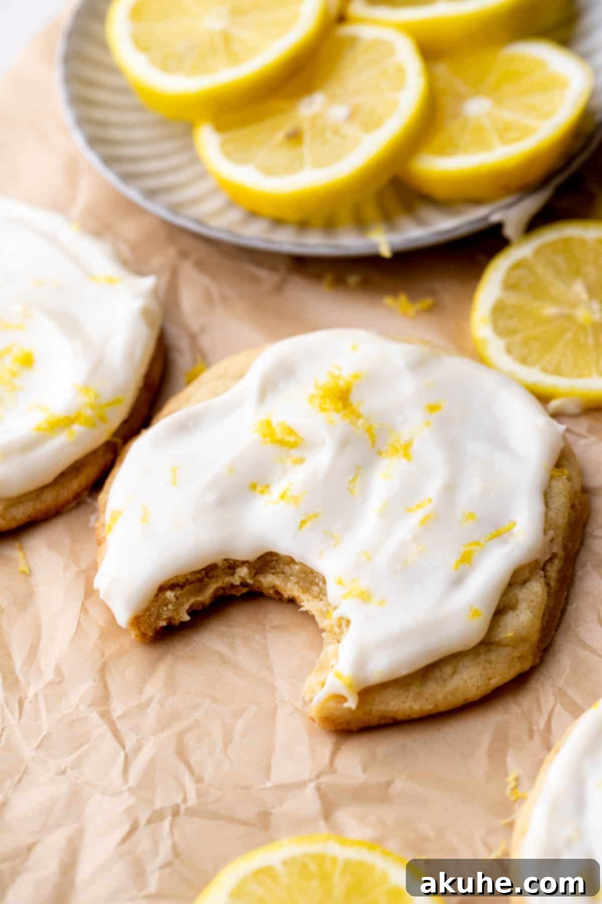 Zesty Lemon Bites 9 A close-up of a lemon cookie with one bite missing, showing its soft interior.