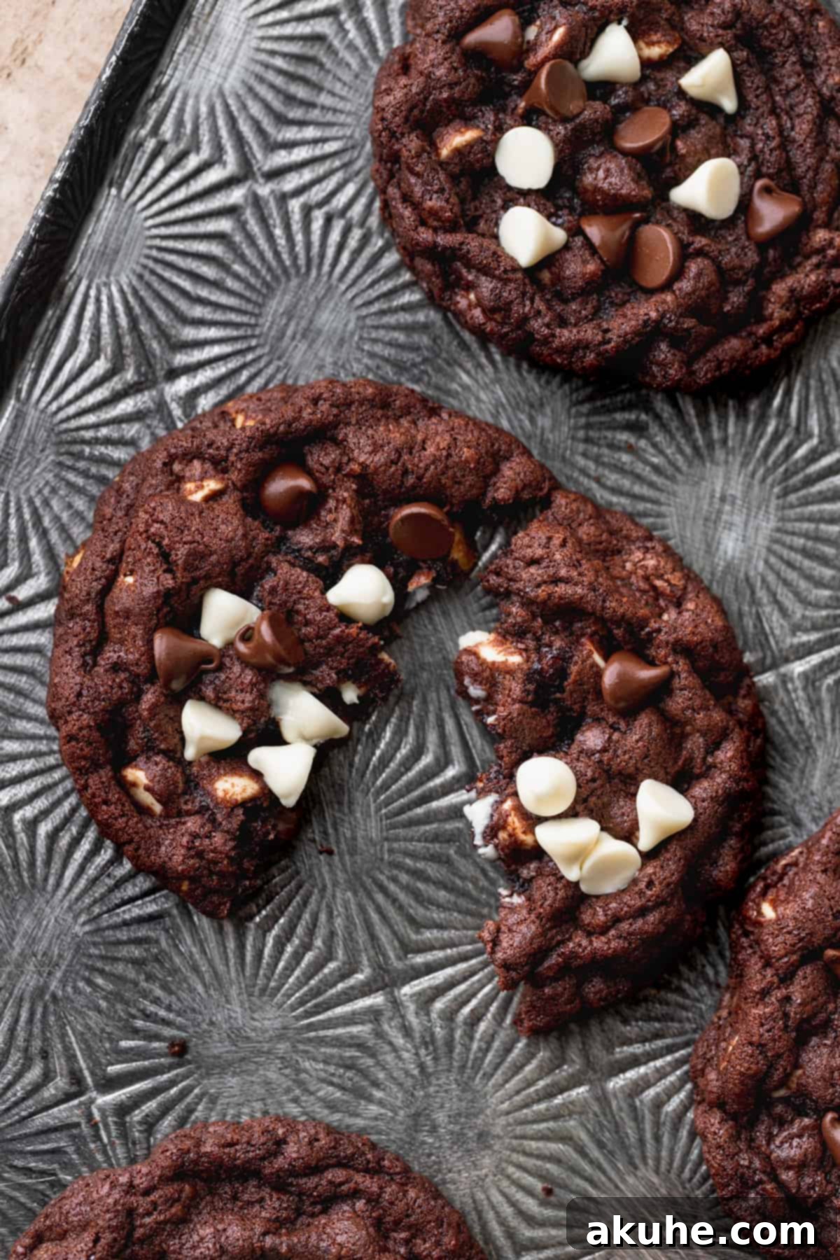 Decadent Double Chocolate White Chip Cookies 3 A freshly baked white chip double chocolate cookie split in half, revealing its fudgy interior and abundant white and dark chocolate chips.