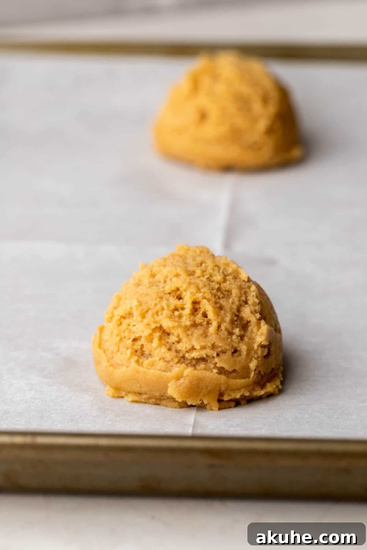 PB&J Cookies 6 Peanut butter cookie dough ball on a cookie sheet.