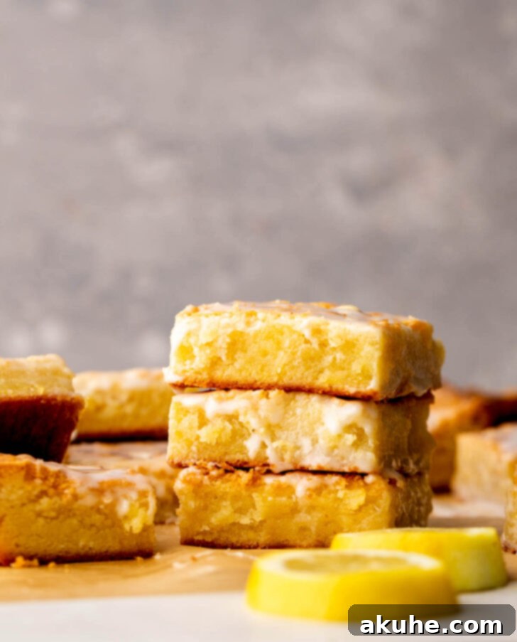Zesty Lemon Brownies 9 A stack of three lemon brownies, showing their thick, fudgy texture and the inviting glaze.