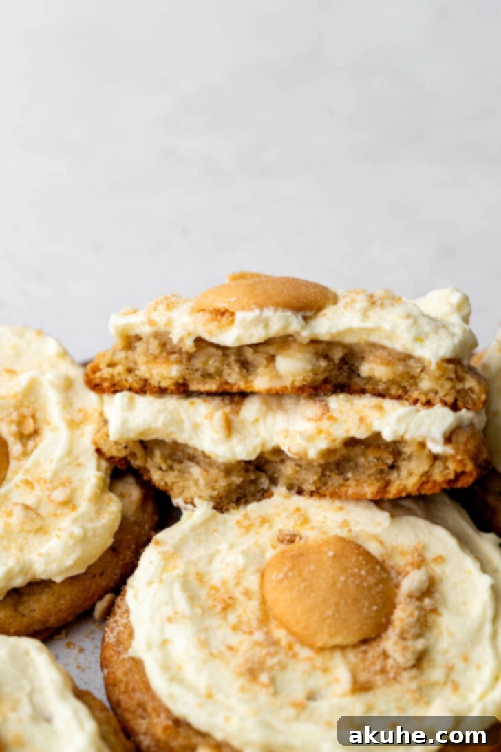 The Ultimate Banana Pudding Cookies 11 One banana pudding cookie split in half, showcasing its rich texture and topping.