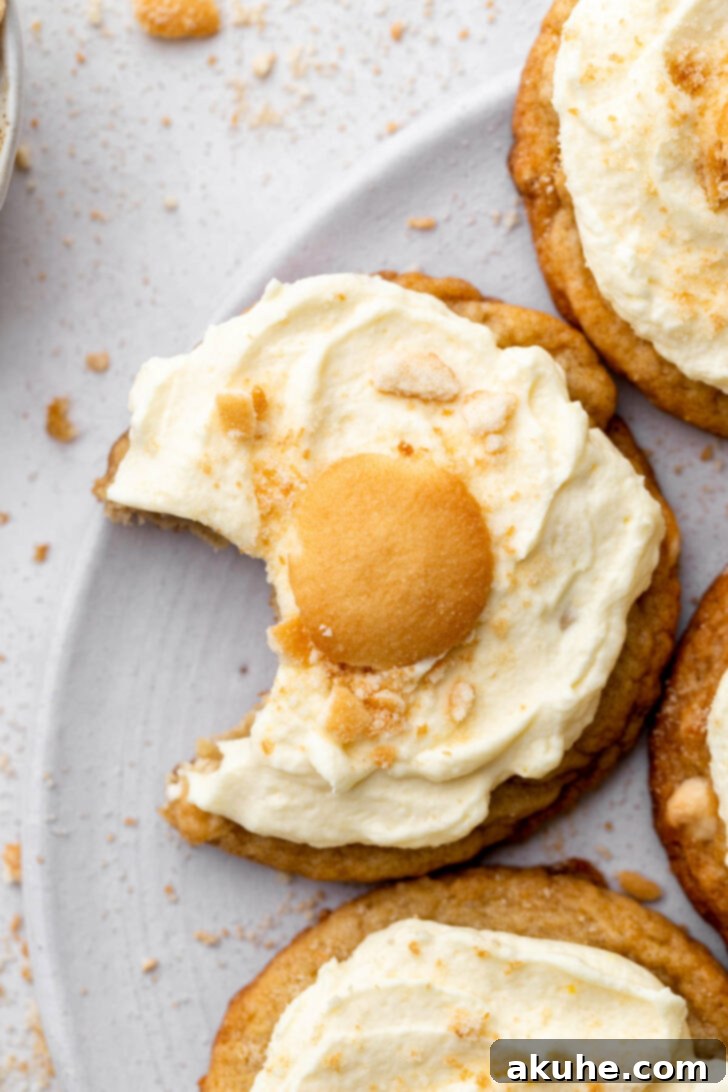 The Ultimate Banana Pudding Cookies 3 A banana pudding cookie with a bite taken out, revealing its soft interior.