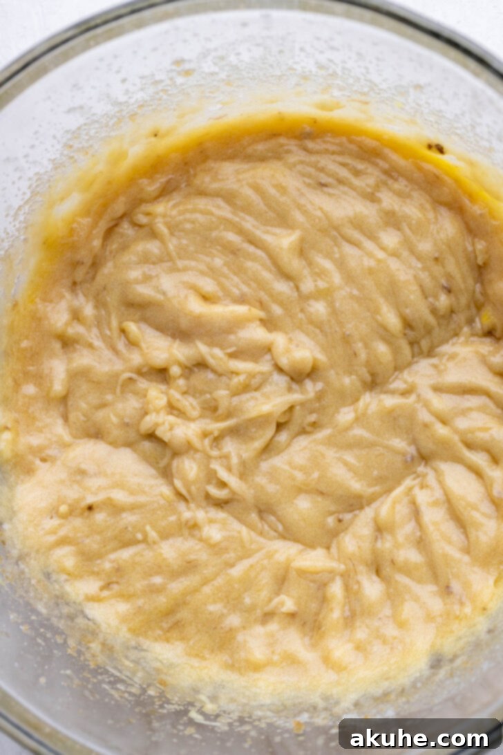 The Ultimate Banana Pudding Cookies 4 Wet ingredients including mashed ripe bananas in a glass bowl, ready for mixing.