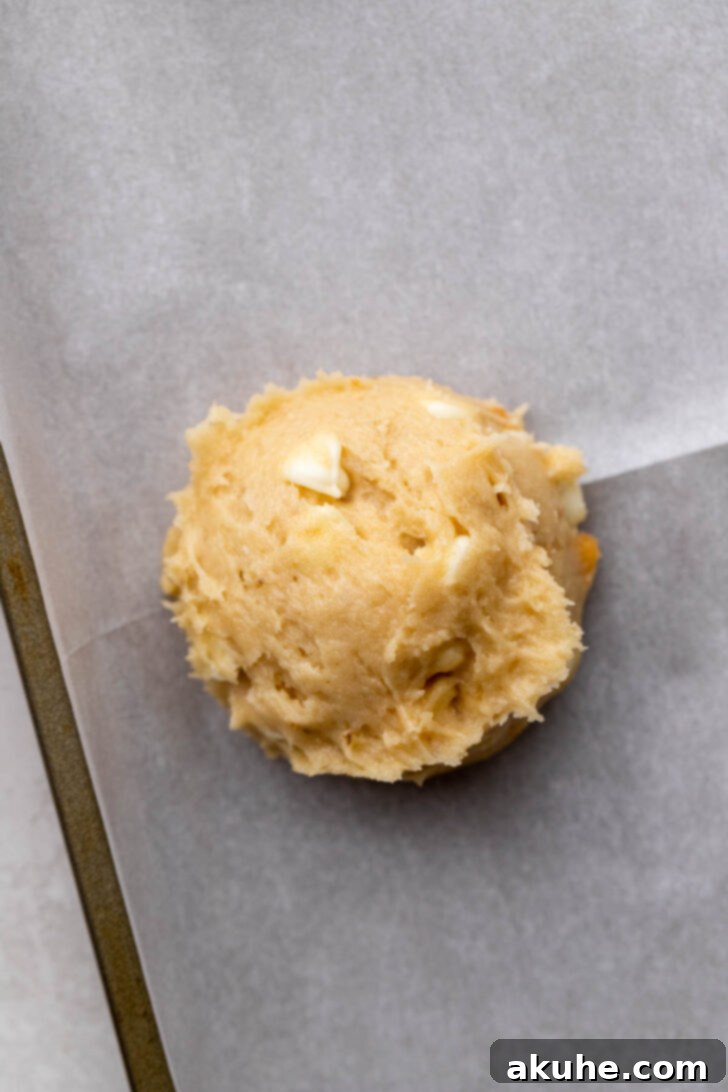 The Ultimate Banana Pudding Cookies 6 A scoop of banana pudding cookie dough placed on parchment paper, ready for baking.