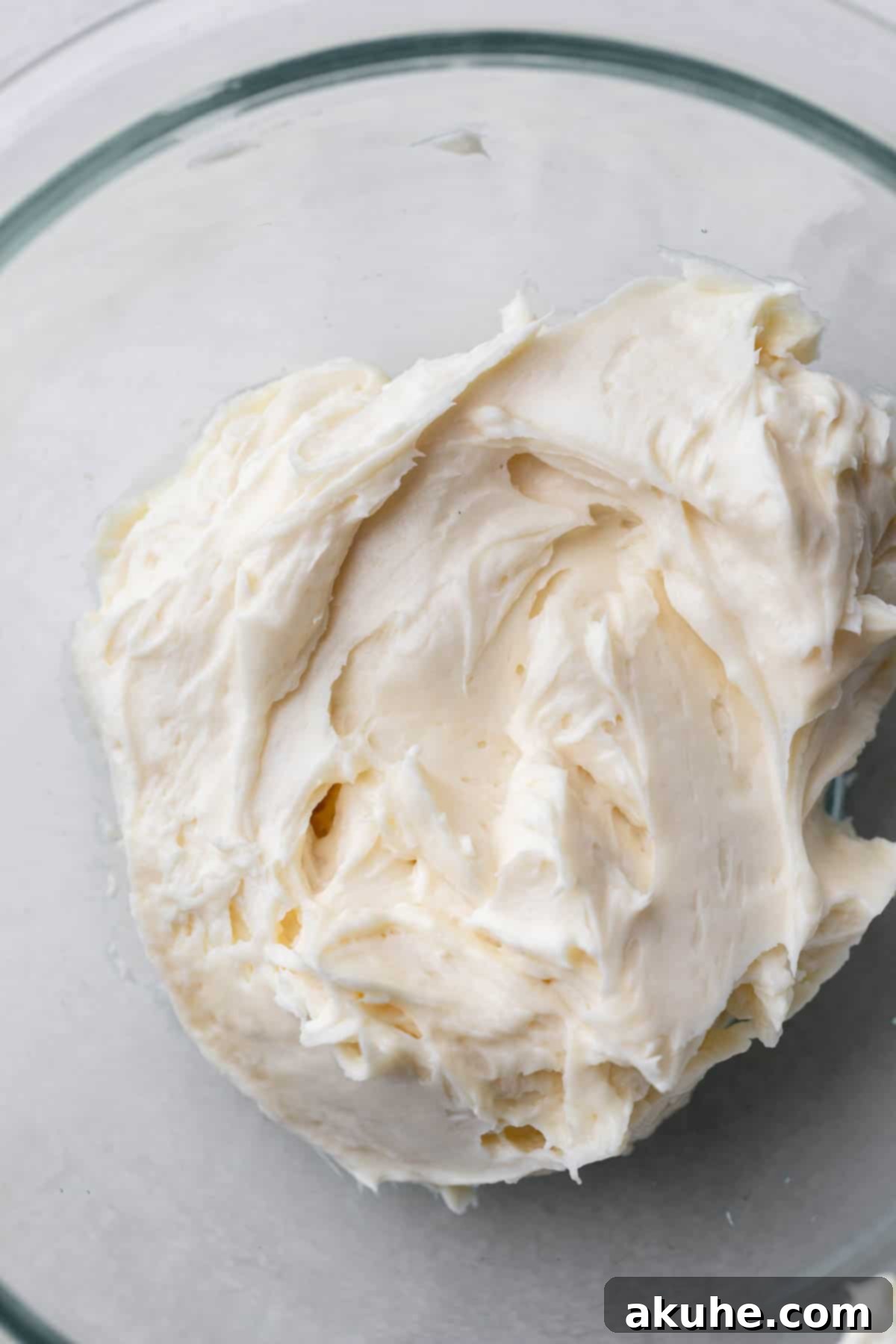 Cheesecake filling in a glass bowl, creamy and smooth.