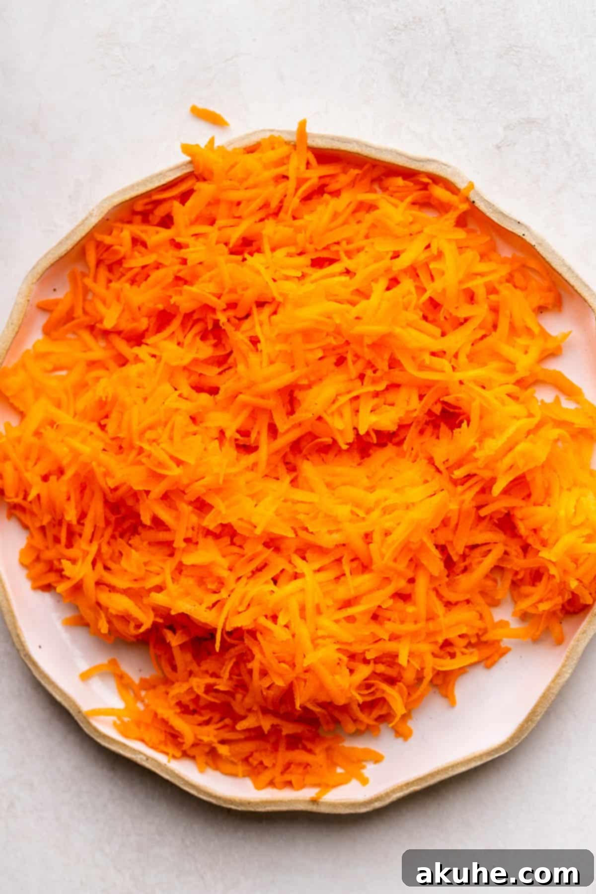 Finely grated carrots on a plate, ready for baking.