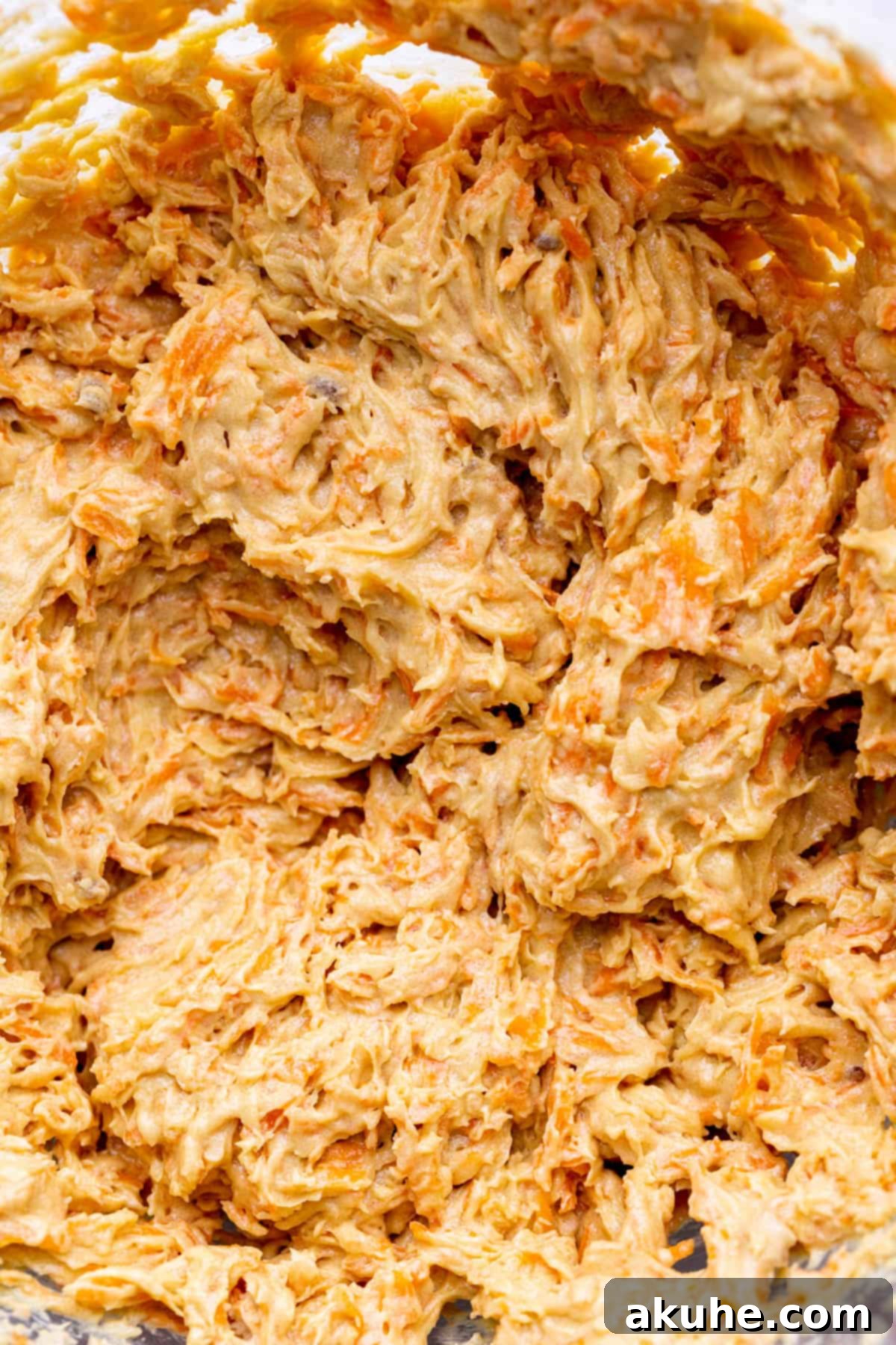 Wet ingredients being mixed in a bowl of a stand mixer.
